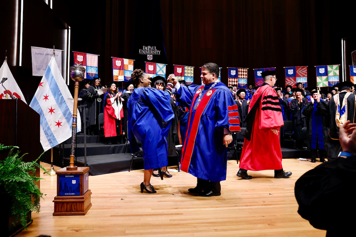 After he received the chain of office, President Rob Manuel shared a high-five with Dani Blackwell, vice president of Staff Counsil and a student retention and operations specialist in New Student and Family Engagement. (DePaul University/Tom Vangel)
